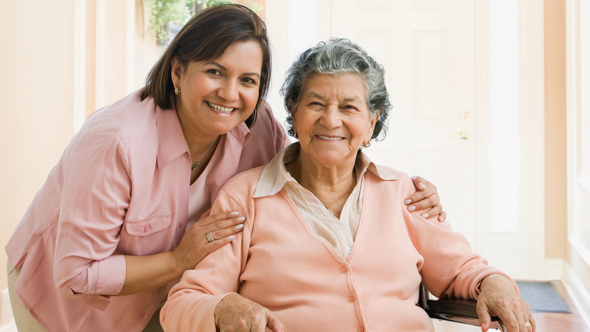 Caring caregiver with happy elderly woman
